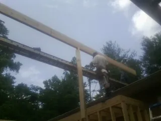 Carpenter setting a ridge beam over a new addition frame — Ice Dam Removal by Roofing Brothers in Ellinger