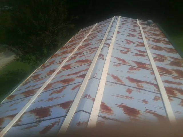 Rusted metal roof panels with new wood purlins before replacement — Storm Damage Roof Repair in Ellinger by Roofing Brothers